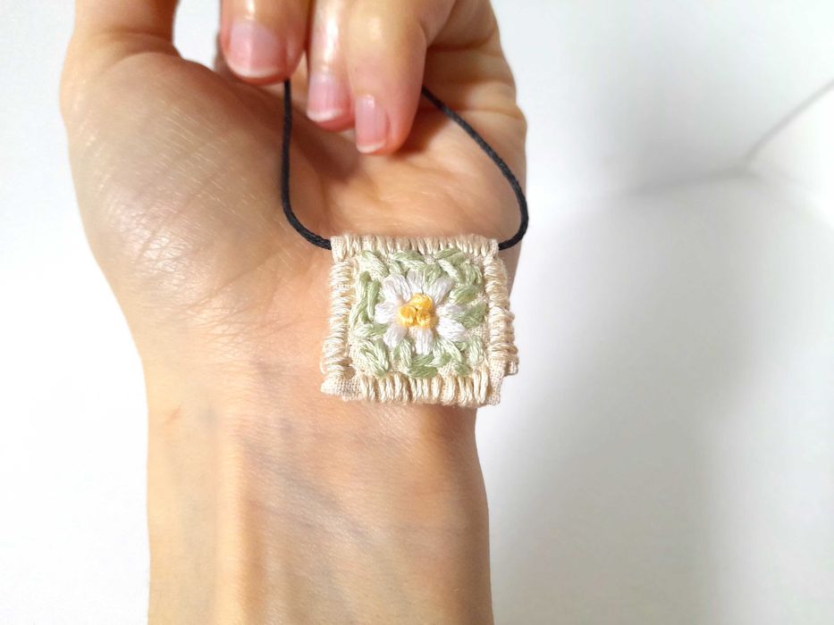 Pulseira bordada à mão com pingente de margarida branca