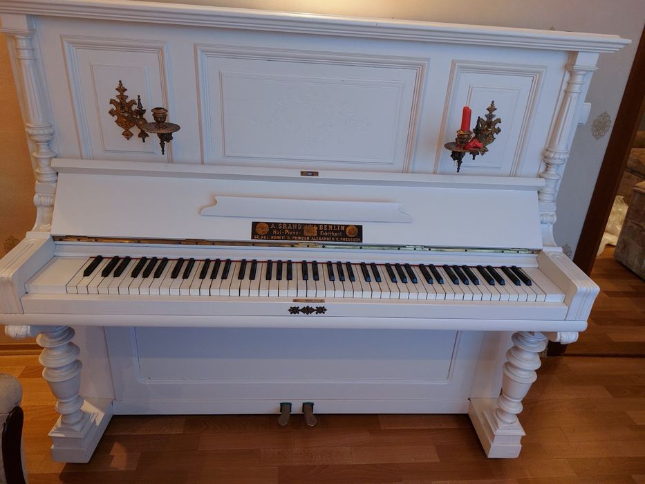 Біле фортепіано із підсвічниками
