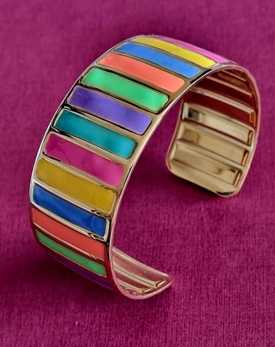 Pulseira dourada, em aço, com riscas coloridas. Fácil colocação.