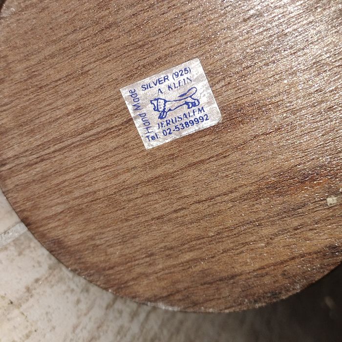 srebrna figurka ptaka (symbolu pokoju) na drewnianym stojaku