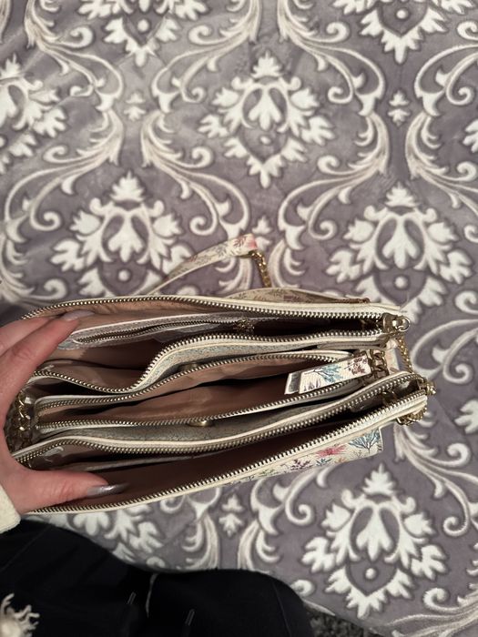 Mala a tiracolo branca com padrao colorido.