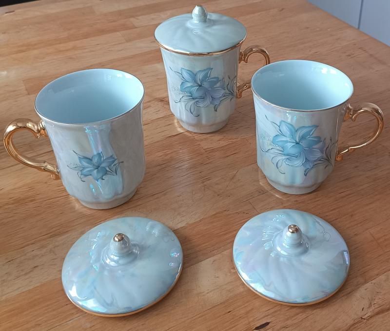 Красива з позолотою та перламутром порцелянова чашка з кришкою на вибі