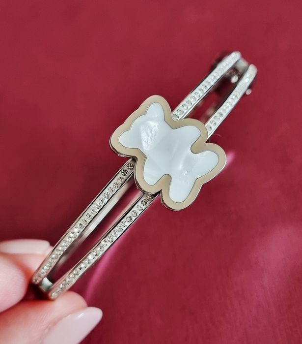 Pulseira/escrava prateada, em aço, com zirconias e um urso em madrepér