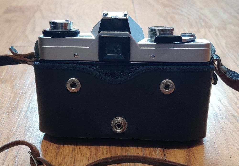 Máquina fotográfica antiga e lentes.