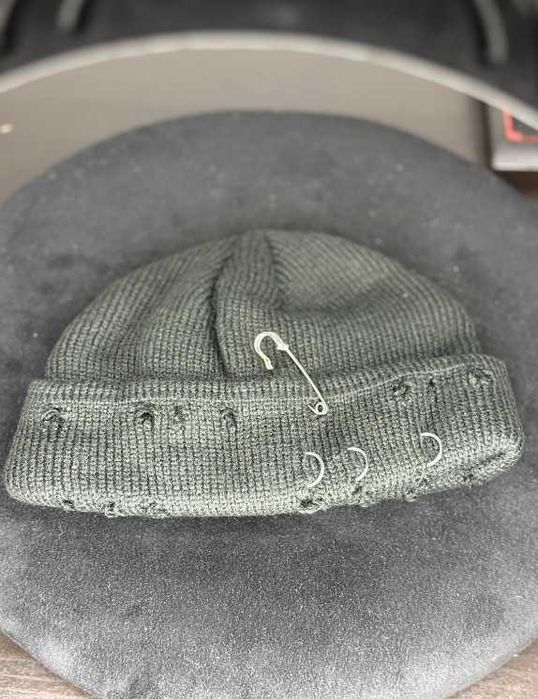 Zielona czapka beanie z efektownymi akcentami piercingu