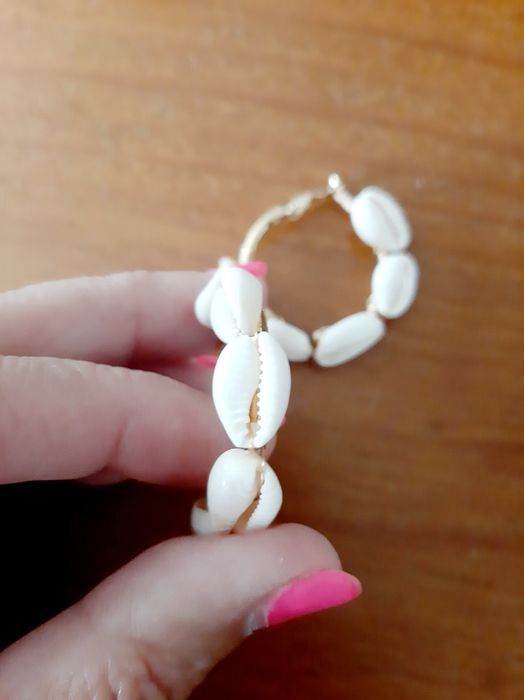 Brincos dourados com búzios