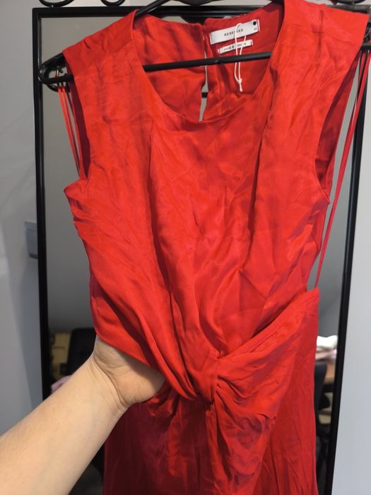 Czerwona sukienka z wyciętymi bokami.