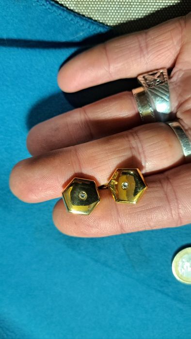 Botões de punho em prata dourada.