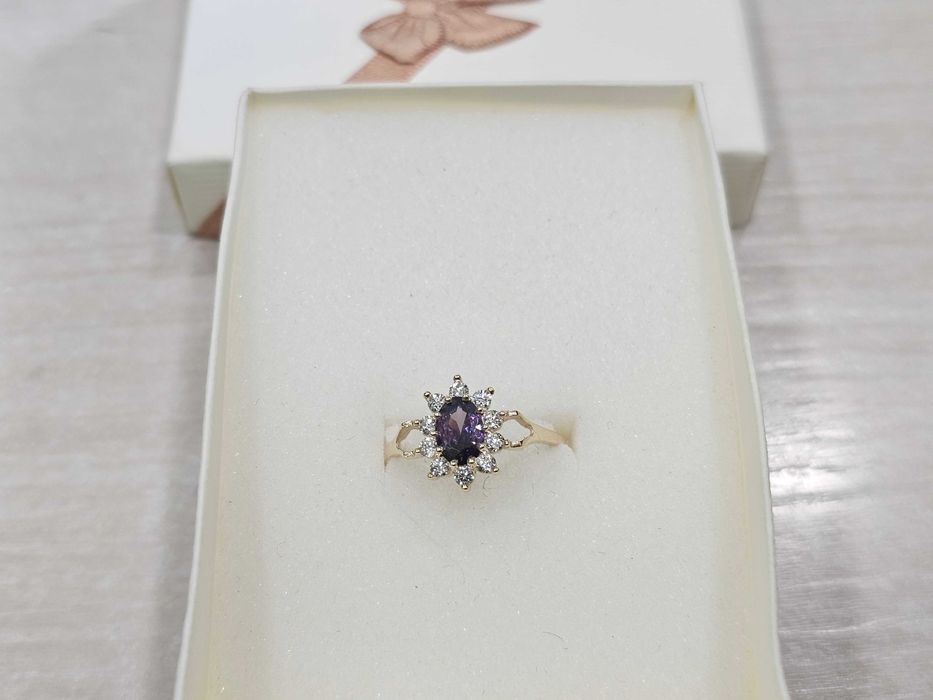 Pierścionek złoty z fioletowym oczkiem otoczony cyrkoniami PR 585