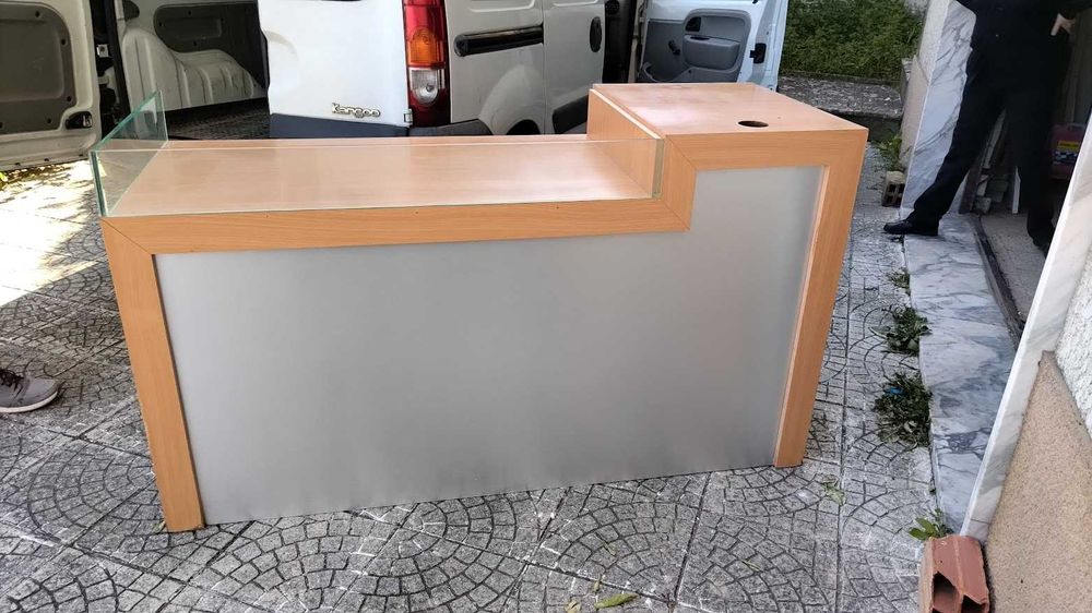 Balcão de atendimento em faia, com a frente revestida a aço escovado