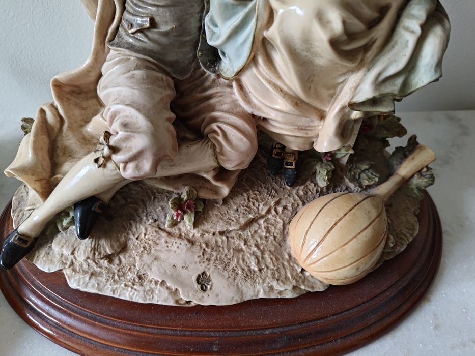 Estátua de dois amantes em base de madeira