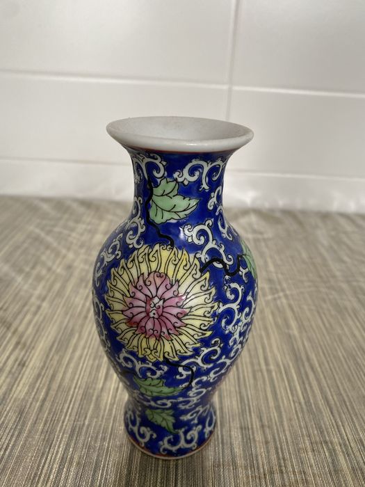 Vaso antigo pequeno com flores entrelaçadas
