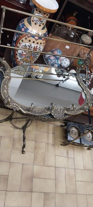 Base para guarda chuvas e espelho de parede com bengaleiro e chapeleiro. Em latão.Mesa meia lua.