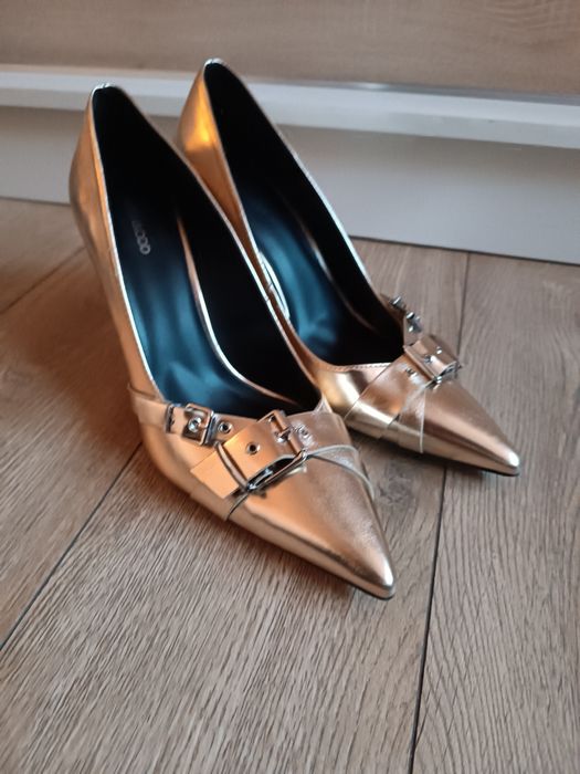 Złote wysokie szpilki