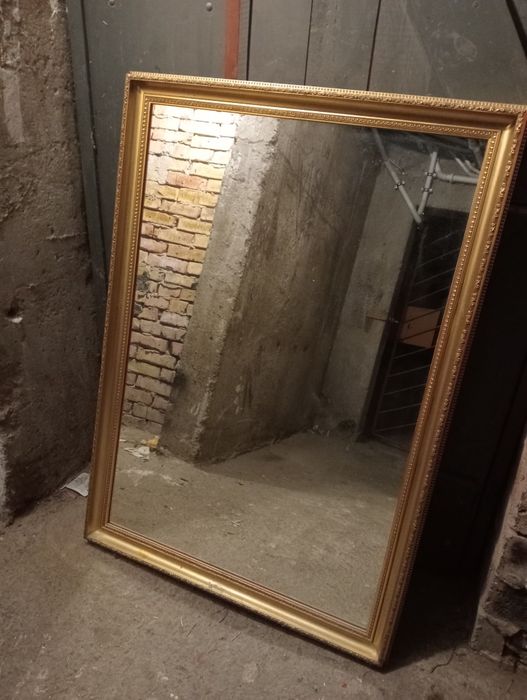 Duże lustro w złotej ramie
