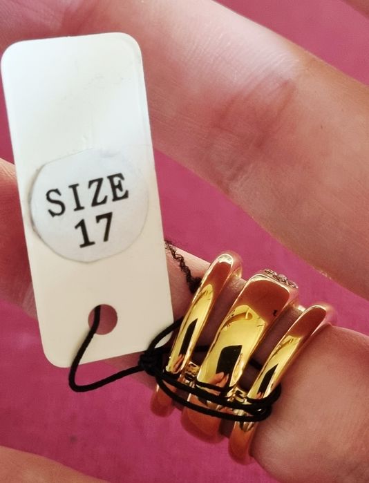 Anel dourado, em aço, com zirconias e uma pedra "olho de gato". T17