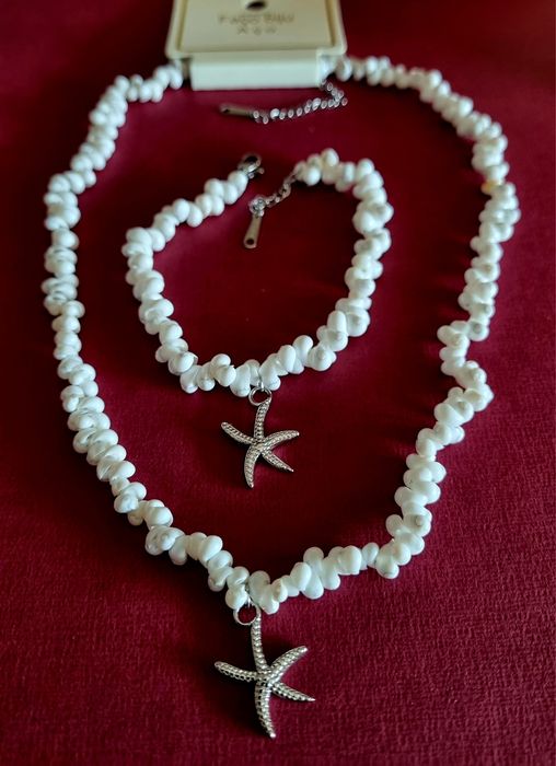Conjunto branco (colar e pulseira), em aço, com estrela do mar prateada.
