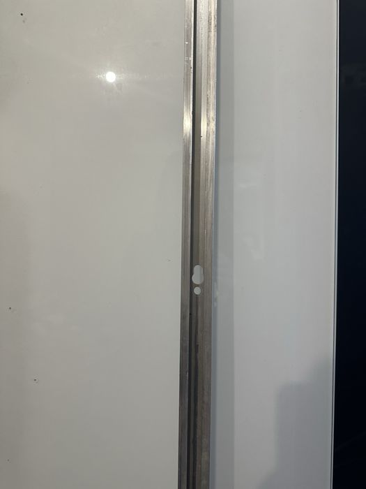 Porta de correr branca com puxador com placa lateral e sistema de correr chão livre