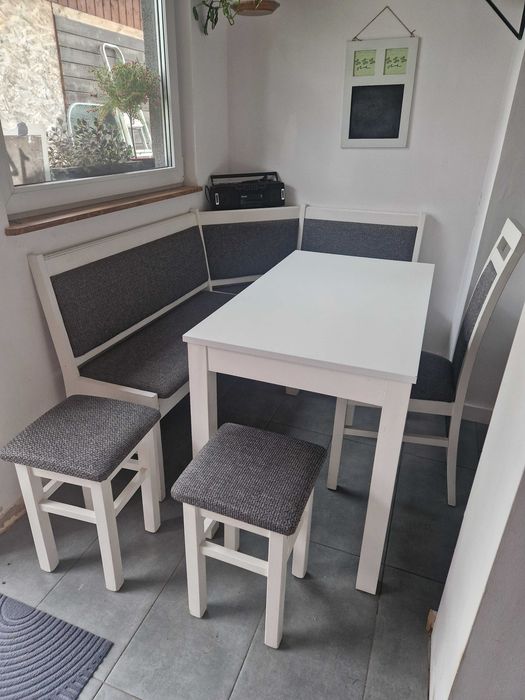 Narożnik kuchenny plus stół, krzesło i taborety.