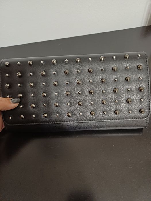 Selling a very modern black studded clutch bag