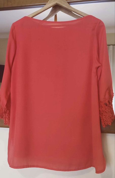 Blusa de senhora, na cor coral. Veste um L.