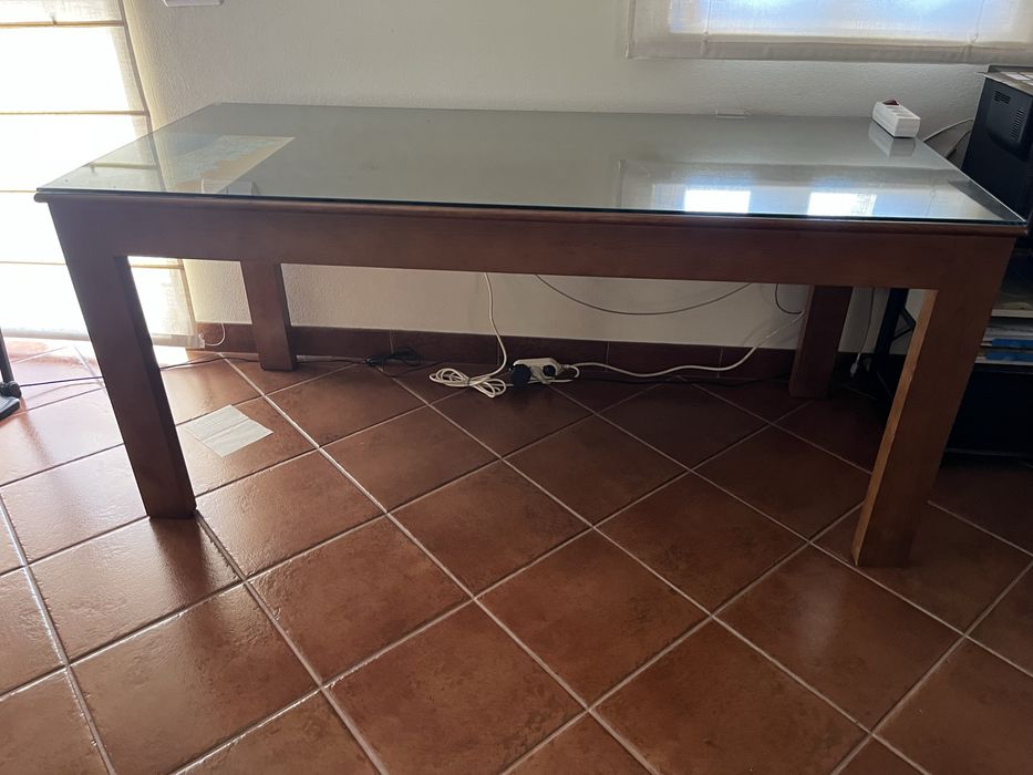 Secretária de madeira maciça. Tampo protegido com vidro.