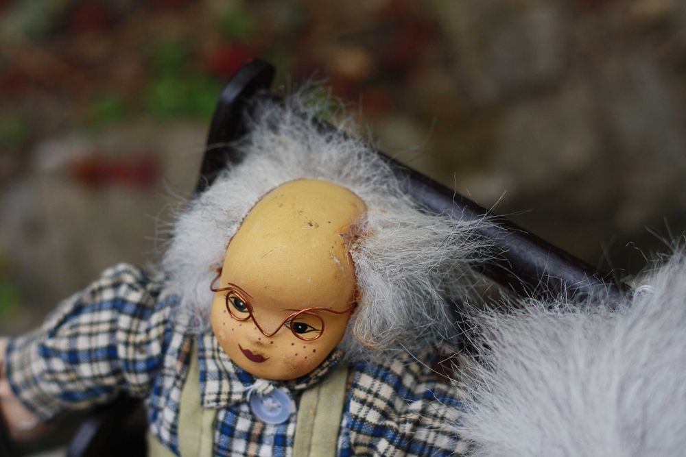 Dwie lalki siedzące na ławce Babcia i Dziadek