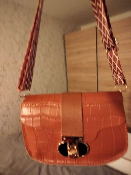 Brązowa torebka typu listonoszka.