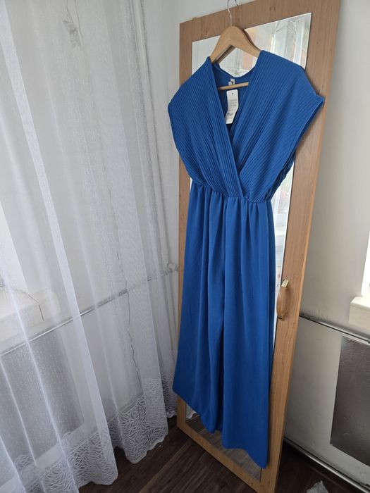 Długi niebieski kombinezon z dekoltem