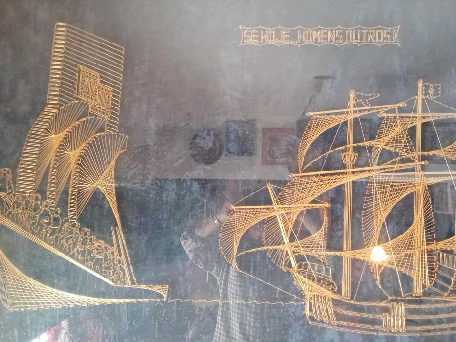 Quadro monumento aos descobrimentos construído com fio dourado.