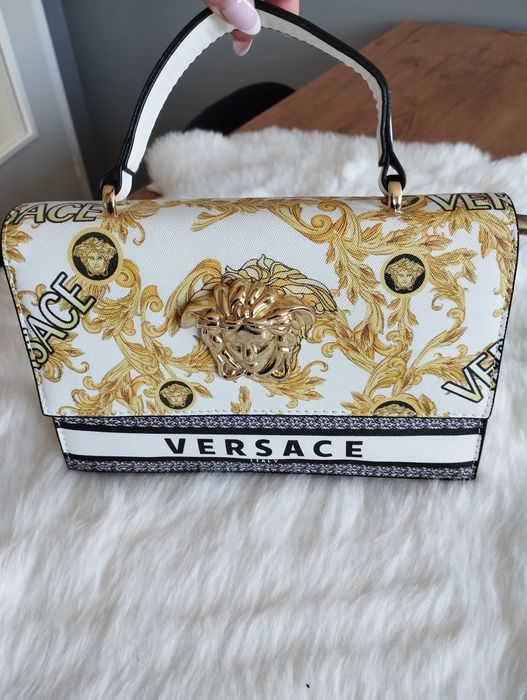 Biała torebka ze złotą aplikacją Versace.