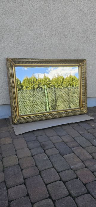 Urocze lustro w rzeźbionej złotej ramie