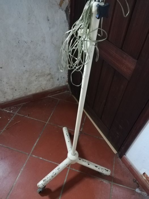 Antigo candeeiro hospitalar, articulado e com tripé de rodas.