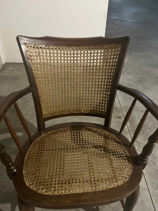 Cadeira de madeira rústica com braços e assento de palha