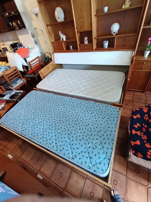 Estúdio com dois colchões e estante em pinho mel