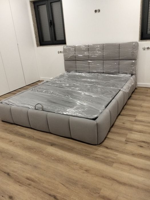 Cama em tecido nova com estrado elevatória incluída.