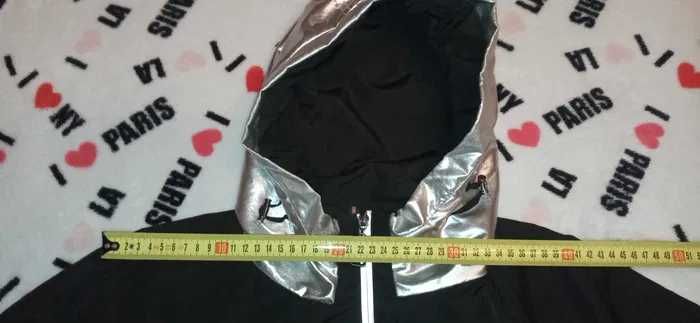 Плащ жіночий чорного кольору з срібними вставками та капюшоном.