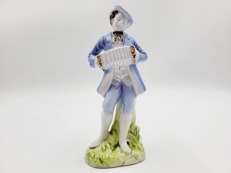 Ceramiczna pastelowa figurka muzykanta grajka z harmonią