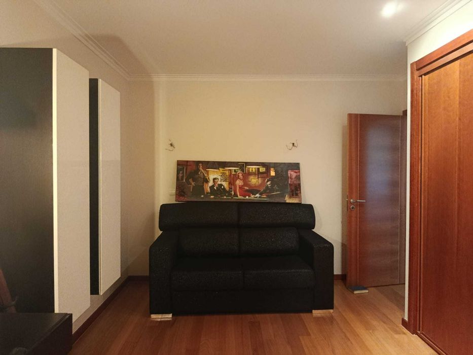 Sofa-cama em tecido preto e prata, encosto rebativel e pés inox polido