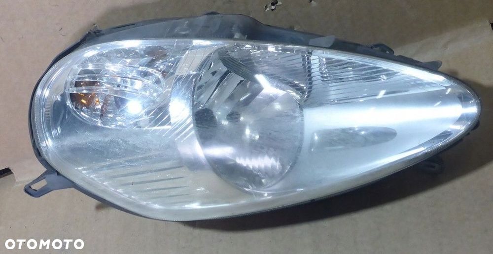 Fiat Grande Punto III Reflektor Lewy 89101387 - 2
