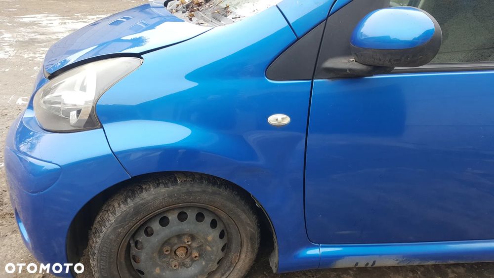BŁOTNIK LEWY PRZÓD PRZEDNI TOYOTA AYGO I LIFT 12-14 LAK. 8U7 - 1