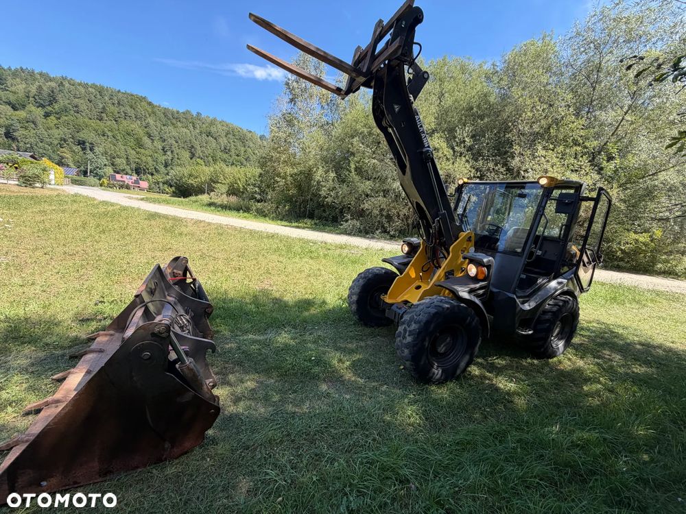 Mecalac AX1000 Ładowarka kołowa łamana 6,5 tony. Udźwig około 3 tony. 2017 rok.  Jak Nowa! Oryginał łyżka KROKODYL otwierana i widły. Mocny silnik DEUTZ 4 cylindry DEUTZ. Zero luzów i wycieków. Aktualne Badania DEKRA BMWT. Wielka Okazja. Maszyna jak nowa z Salonu. 2900 mtg. Pochodzi z Norweskiego urzędu gminy. Dodatkowe linie Hydrauliczne. Szybka wolna Jazda Rewers Hydrostatic. Wersja Norweska Mocne doświetlenie dodatkowe grzanie. kabina Ogrzewana wentylowana! Zmiana Osprzętu Hydrauliczna! pełne sterowanie z dżojstika! Podzespoły pompy suche, czytelne tabliczki! OKAZJA - 13