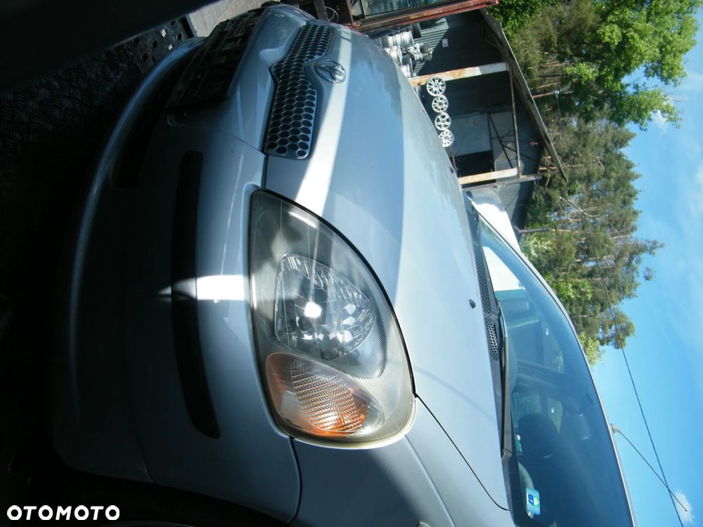 Toyota Yaris I (99-03r.) 1.0 B 68KM. Silnik 1SZ-FE Skrzynia MTM 5F lakier 199. Cały na części. GWARANCJA !!!  Przód Tył Zestaw Komplet Drzwi Klapa Zderzak Błotnik Maska Grill Atrapa Szyba Pas Lampa Lusterko Boczki Fotel Kanapa Kokpit Deska Rozdzielcza Przełącznik Włącznik Sterownik Przewody Wiązka Instalacja Moduł Komputer Czujnik Listwa Pompa Alternator Wtryski Głowica Rozrusznik Kompresor Sprzęgło Dwumas Silnik Skrzynia ABS Klimatyzacji Paliwa Wspomagania Kolektor Turbina Przepustnica Zawór Chłodnica Koło Hak Belka Sanki Zawieszenie Mcpherson Półoś Amortyzator Wydech Tłumik Zacisk Most - 7