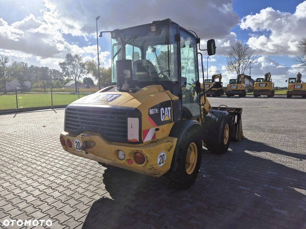 Caterpillar 907H / z Niemiec / Łyżka otwierana + Widły / 6700 mth / - 4