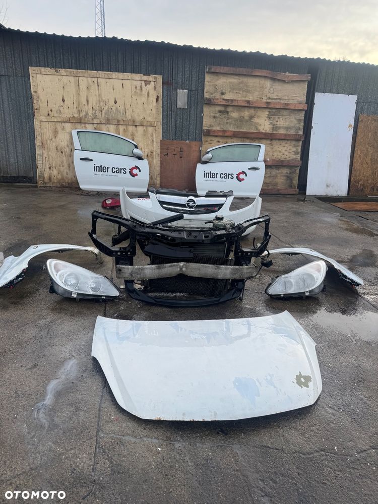 Opel Corsa D biała maska drzwi prawe lewe przednie przód pas przedni chłodnice wody klimy lampy lampa przednia prawa lewa błotnik prawy lewy biały białe zderzak przód przedni klapa bagażnika klapa tył tylnia lampa prawa lewa belka pod zderzak - 1