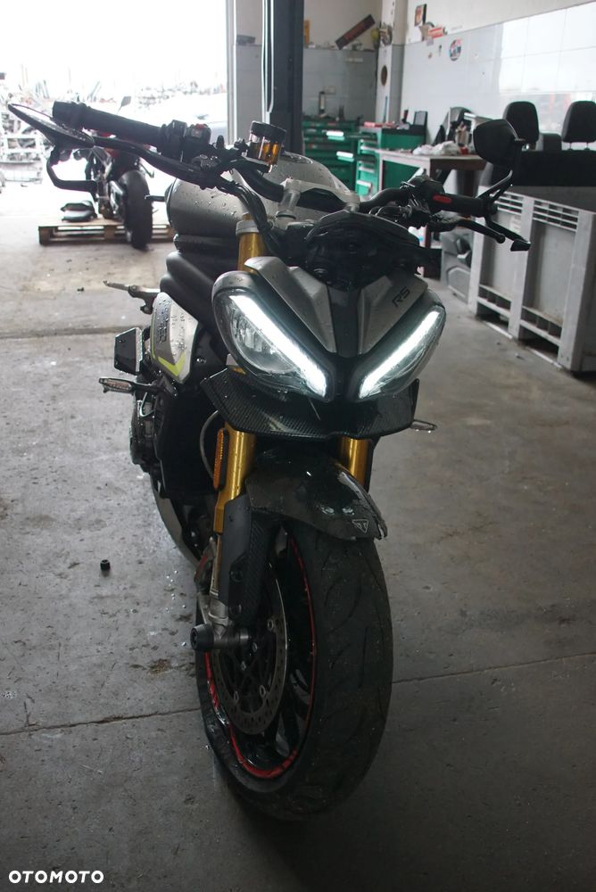 Triumph Speed Triple 1200 rs 2022 na części 692106889 SILNIK: silnik kompletny, blok silnika, głowica cylindrów, pokrywa zaworów, uszczelka głowicy, cylinder, tuleja cylindra, tłok, pierścienie tłokowe, sworzeń tłoka, korbowód, wał korbowy, panewki wału, wałek rozrządu, koło rozrządu, łańcuch rozrządu, napinacz rozrządu, ślizg rozrządu, zawór ssący, zawór wydechowy, sprężyna zaworowa, popychacz zaworu, dźwigienka zaworowa, uszczelniacz zaworowy, miska olejowa, korek spustowy oleju, pompa oleju, smok olejowy, filtr oleju, chłodnica oleju, przewód olejowy, obudowa filtra oleju, czujnik ciśnienia oleju, pokrywa alternatora, pokrywa sprzęgła, dekiel silnika, uszczelki silnika, engine assembly, engine block, cylinder head, valve cover, piston, piston rings, connecting rod, crankshaft, camshaft, timing chain, oil pump.  UKŁAD PALIWOWY I DOLOTOWY: zbiornik paliwa, bak paliwa, korek wlewu paliwa, pompa paliwa, kosz pompy paliwa, filtr paliwa, przewód paliwowy, listwa wtryskowa, wtryskiwacz, regulator ciśnienia paliwa, przepustnica, korpus przepustnicy, silniczek krokowy, czujnik położenia przepustnicy TPS, manetka gazu, rolgaz, elektroniczny gaz ride-by-wire, airbox, obudowa filtra powietrza, filtr powietrza, króciec dolotowy, kolektor dolotowy, czujnik temperatury powietrza, czujnik ciśnienia MAP, fuel tank, fuel pump, fuel injector, throttle body, air filter.  SPRZĘGŁO I SKRZYNIA BIEGÓW: kosz sprzęgłowy, piasta sprzęgła, tarcze sprzęgłowe, przekładki sprzęgła, sprężyny sprzęgła, docisk sprzęgła, pompa sprzęgła, wysprzęglik, przewód sprzęgła, klamka sprzęgła, skrzynia biegów, wałek sprzęgłowy, wałek zdawczy, koła zębate skrzyni, wodzik zmiany biegów, bęben zmiany biegów, czujnik biegu, dźwignia zmiany biegów, cięgno zmiany biegów, quickshifter, czujnik quickshiftera, clutch basket, clutch plates, gearbox, transmission shaft, gear selector drum, shift fork.  NAPĘD TYLNEGO KOŁA: zębatka przednia, zębatka tylna, łańcuch napędowy, spinka łańcucha, napinacz łańcucha, prowadnica łańcucha, osłona łańcucha, guma zabieraka, zabierak zębatki, mocowanie zębatki, front sprocket, rear sprocket, drive chain, chain adjuster, chain guide, chain guard, sprocket carrier.  UKŁAD WYDECHOWY: kolektory wydechowe, rury wydechowe, tłumik końcowy, tłumik środkowy, katalizator, osłona tłumika, zawór wydechowy, silniczek zaworu wydechowego, linki zaworu wydechowego, sonda lambda, uszczelka kolektora, obejma wydechu, mocowanie tłumika, exhaust headers, muffler, silencer, catalytic converter, exhaust valve, oxygen sensor, heat shield.  UKŁAD CHŁODZENIA: chłodnica, wentylator chłodnicy, osłona chłodnicy, korek chłodnicy, zbiorniczek wyrównawczy, pompa wody, termostat, obudowa termostatu, przewód chłodnicy, wąż układu chłodzenia, króciec wody, czujnik temperatury płynu, radiator, radiator fan, coolant reservoir, water pump, thermostat, coolant hose.  ZAWIESZENIE PRZEDNIE: lagi przednie, widelec przedni, goleń widelca, rura nośna, dolna półka, górna półka, sztyca widelca, uszczelniacz lagi, uszczelniacz przeciwpyłowy, sprężyna widelca, kartridż amortyzatora, regulator tłumienia, korek lagi, olej do lag, amortyzator skrętu, steering damper, front fork, fork tube, fork seal, fork cartridge, triple clamp, upper yoke, lower yoke.  ZAWIESZENIE TYLNE: amortyzator tylny, sprężyna amortyzatora, wahacz jednoramienny, oś wahacza, łożysko wahacza, kiwak zawieszenia, łącznik amortyzatora, regulator napięcia wstępnego, mocowanie amortyzatora, rear shock, shock absorber, single-sided swingarm, swingarm pivot, suspension linkage.  UKŁAD HAMULCOWY: zacisk hamulcowy przedni lewy, zacisk hamulcowy przedni prawy, zacisk hamulcowy tylny, jarzmo zacisku, tłoczek hamulcowy, zestaw naprawczy zacisku, klocki hamulcowe przednie, klocki hamulcowe tylne, tarcza hamulcowa przednia, tarcza hamulcowa tylna, pompa hamulcowa przednia, pompa hamulcowa tylna, przewód hamulcowy, przewód w oplocie, zbiorniczek płynu hamulcowego, klamka hamulca, pedał hamulca, czujnik światła stop, moduł ABS, pompa ABS, czujnik ABS, pierścień ABS, front brake caliper, rear brake caliper, brake pads, brake disc, brake rotor, brake master cylinder.  KOŁA I OPONY: felga przednia, felga tylna, koło przednie, koło tylne, oś koła przedniego, oś koła tylnego, dystans koła, łożysko koła, uszczelniacz koła, piasta koła, nakrętka tylnego koła, zawór opony, czujnik ciśnienia TPMS, opona przednia, opona tylna, front wheel, rear wheel, wheel rim, wheel axle, wheel bearing, wheel hub, tire, tyre, TPMS sensor.  KIEROWNICA I STEROWANIE: kierownica, mocowanie kierownicy, riser kierownicy, lewa manetka, prawa manetka, ciężarki kierownicy, końcówki kierownicy, lusterko lewe, lusterko prawe, uchwyt lusterka, klamka sprzęgła, klamka hamulca, przełącznik zespolony lewy, przełącznik zespolony prawy, rolgaz, stacyjka, antena stacyjki, amortyzator skrętu, handlebar, handlebar clamp, grip, bar end, rear-view mirror, switchgear, ignition switch.  RAMA I PODWOZIE: rama główna, rama tylna, subframe, wspornik ramy, mocowanie silnika, śruba mocowania silnika, crash pad, slider ramy, osłona ramy, stopka boczna, czujnik stopki bocznej, sprężyna stopki, uchwyt tablicy rejestracyjnej, mocowanie podnóżka, podnóżek kierowcy lewy, podnóżek kierowcy prawy, podnóżek pasażera lewy, podnóżek pasażera prawy, set podnóżków, rearset, frame, rear subframe, engine mount, crash protector, side stand, footpeg.  OWIEWKI I NADWOZIE: owiewka przednia, owiewka boczna lewa, owiewka boczna prawa, owiewka tylna, boczek lewy, boczek prawy, osłona chłodnicy, osłona silnika, belly pan, pług pod silnik, błotnik przedni, błotnik tylny, nadkole, hugger, przednia szyba, szyba sportowa, deflektor, wlot powietrza, osłona ramy, osłona wahacza, osłona karbonowa, carbon cover, fairing, side panel, front fender, rear fender, windscreen, radiator cover.  SIEDZENIE I TYLNA CZĘŚĆ: siedzenie kierowcy, siedzenie pasażera, kanapa, zamek siedzenia, linka zamka siedzenia, uchwyt pasażera, ogon motocykla, stelaż tylny, wypełnienie zadupka, osłona siedzenia, seat cowl, rider seat, passenger seat, seat lock, tail section.  ELEKTRYKA I ELEKTRONIKA: wiązka elektryczna główna, wiązka przednia, wiązka tylna, sterownik silnika ECU, moduł zapłonowy, regulator napięcia, alternator, stator, rotor alternatora, rozrusznik, przekaźnik rozrusznika, akumulator, skrzynka bezpieczników, bezpiecznik, przekaźnik, cewka zapłonowa, świeca zapłonowa, fajka świecy, przewód masowy, złącze elektryczne, gniazdo USB, immobilizer, antena immobilizera, czujnik przechyłu, czujnik położenia wału, czujnik położenia wałka, czujnik prędkości, czujnik temperatury, czujnik ciśnienia, wiring harness, ECU, voltage regulator, alternator, starter motor, starter relay, battery, fuse box, ignition coil, spark plug.  OŚWIETLENIE I ZEGARY: reflektor przedni, lampa przednia LED, światło mijania, światło drogowe, moduł reflektora, kierunkowskaz przedni lewy, kierunkowskaz przedni prawy, kierunkowskaz tylny lewy, kierunkowskaz tylny prawy, lampa tylna, światło stop, lampka tablicy rejestracyjnej, licznik, zegary, wyświetlacz TFT, panel wskaźników, obudowa licznika, czujnik poziomu paliwa, headlight, LED headlamp, tail light, brake light, turn signal, indicator, instrument cluster, dashboard, TFT display.  SYSTEMY ELEKTRONICZNE: moduł kontroli trakcji, traction control, czujnik IMU, moduł ride-by-wire, tempomat, przełącznik tempomatu, quickshifter up and down, moduł ABS, czujnik kąta pochylenia, moduł Bluetooth, antena, moduł bezkluczykowy, keyless module, kluczyk, pilot, immobilizer key, przełącznik trybów jazdy, riding mode switch.  ŚRUBY, ŁOŻYSKA I DROBNE CZĘŚCI: komplet śrub, śruba owiewki, nakrętka osi, tuleja dystansowa, podkładka, spinka, zatrzask, kołek montażowy, guma mocująca, silentblock, obejma, uchwyt przewodu, łożysko główki ramy, łożysko igiełkowe, łożysko kulkowe, simmering, uszczelka, oring, zestaw naprawczy, - 13