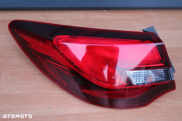 LAMPA LEWA TYLNA LEWY TYŁ W BŁOTNIK OPEL ASTRA J SEDAN EUROPA ORYGINALNA 25870153