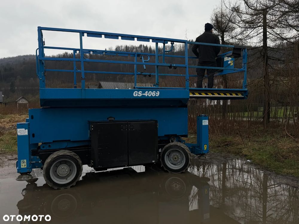 Genie Zwyżka Terenowa GS-4069RT Podnośnik Nożycowy Dźwig 14,5 metra jak Nowa z salonu! 1300 mtg. 2016 rok, Fabryczna przetwornica! 2x Gniazdo 230v góra dół. Pochodzi z Norweskiego urzędu Komuny. Zadbana! 4x4 Silnik Kubota. Zero Luzów i wycieków. Aktualne Serwisy DEKRA BMWT. Wysuwany Balkon. Sterowana z dołu i góry. Okazja Tanio !! Dokumentacja! Bez DPF, adBLUE - 25
