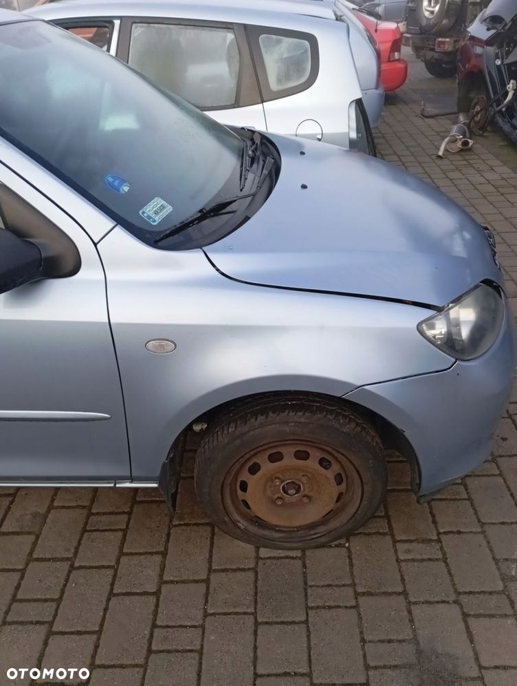MAZDA 2 II BŁOTNIK PRAWY PRZEDNI PRZÓD 27P - 1