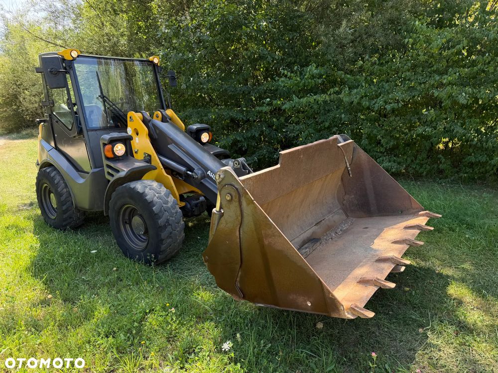 Mecalac AX1000 Ładowarka kołowa łamana 6,5 tony. Udźwig około 3 tony. 2017 rok.  Jak Nowa! Oryginał łyżka KROKODYL otwierana i widły. Mocny silnik DEUTZ 4 cylindry DEUTZ. Zero luzów i wycieków. Aktualne Badania DEKRA BMWT. Wielka Okazja. Maszyna jak nowa z Salonu. 2900 mtg. Pochodzi z Norweskiego urzędu gminy. Dodatkowe linie Hydrauliczne. Szybka wolna Jazda Rewers Hydrostatic. Wersja Norweska Mocne doświetlenie dodatkowe grzanie. kabina Ogrzewana wentylowana! Zmiana Osprzętu Hydrauliczna! pełne sterowanie z dżojstika! Podzespoły pompy suche, czytelne tabliczki! OKAZJA - 2